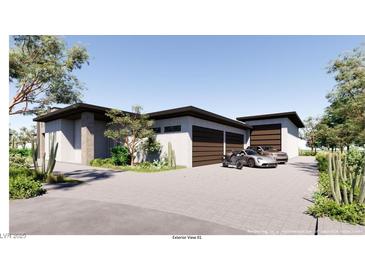 Contemporary home showcasing a multi-car garage, desert landscaping, and modern architectural details at 5855 St Ebbes Ct, Las Vegas, NV 89131