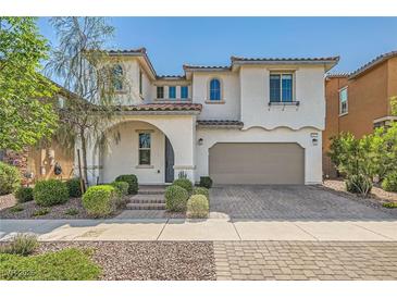 Charming two-story home with stucco siding, arched entryway, and manicured landscaping at 632 Cadence Vista Dr, Henderson, NV 89011