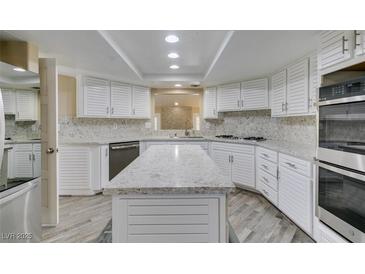 Bright kitchen with white cabinets, stone countertops, stainless steel appliances, and an island at 7217 Mission Hills Dr, Las Vegas, NV 89113