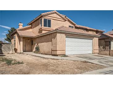 Two-story home featuring a two-car garage, desert landscaping, and a tile roof at 725 Weatherstone Dr, Las Vegas, NV 89110