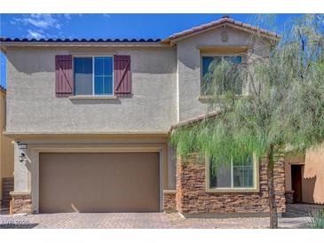 Charming two-story home with a two-car garage, stone accents, and colorful, desert landscaping at 1114 Junipine Ave, North Las Vegas, NV 89081