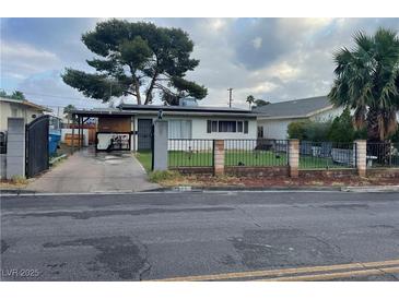 Charming single-story home featuring a well-maintained lawn and a classic fence for a welcoming curb appeal at 1917 Cedar Ave, Las Vegas, NV 89101