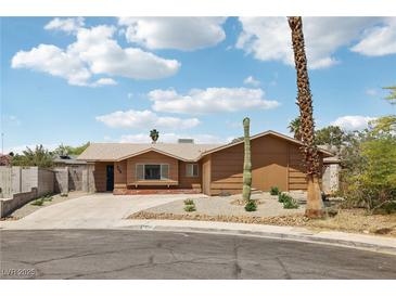 Ranch home featuring a desert landscape, brown exterior, and a long driveway at 204 Breeze St, Las Vegas, NV 89145