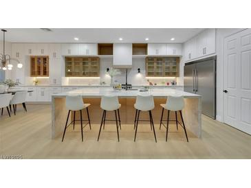 Modern kitchen features a large island with seating, custom cabinets, and stainless steel appliances at 2621 Spalding Dr, Las Vegas, NV 89134