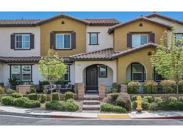 Charming two-story townhome featuring stucco siding, a tiled roof, and a cozy front patio with seating area at 3179 Mura Del Prato Ave, Henderson, NV 89044