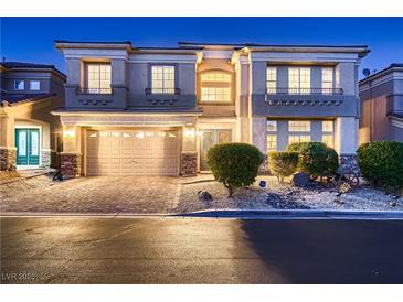 Charming two-story home featuring manicured landscaping and a two-car garage at twilight at 6750 Quapaw St, Las Vegas, NV 89149