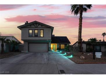 Charming two-story home with a large driveway, well-manicured lawn, and beautiful landscaping at twilight at 7018 Berkshire Pl, Las Vegas, NV 89147