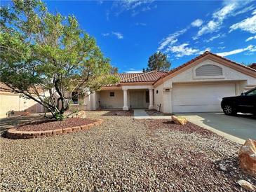 Charming single-story home with a xeriscaped yard, a red tile roof, and an attached two-car garage at 8513 Lynhurst Dr, Las Vegas, NV 89134