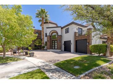 Two story home featuring a brick driveway, manicured lawn, and desert landscaping at 9501 Balatta Canyon Ct, Las Vegas, NV 89144