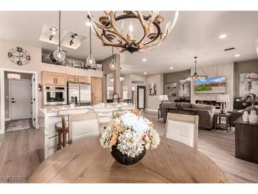 Bright, open-concept kitchen and living room featuring modern appliances and decorative lighting at 10713 Shoalhaven Dr, Las Vegas, NV 89134