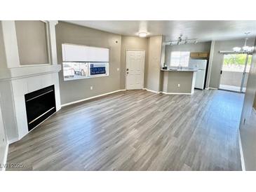 Open living room featuring hard surface floors, a fireplace, and plenty of natural light at 1881 W Alexander Rd # 1128, North Las Vegas, NV 89032