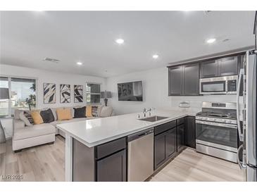 Modern kitchen features stainless steel appliances, ample counter space, and open floor plan at 6150 Foxes Dale St, Las Vegas, NV 89166