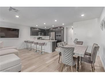 Inviting living room with modern kitchen, dining area, and breakfast bar seating at 6150 Foxes Dale St, Las Vegas, NV 89166