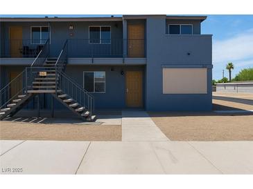 Two-story apartment building with a modern gray exterior, staircases and balconies, and a well-maintained landscape at 841 A, Boulder City, NV 89005