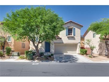 Inviting two-story home featuring a two-car garage, lovely desert landscaping, and charming architectural details at 8824 Charm Canyon Ave, Las Vegas, NV 89178