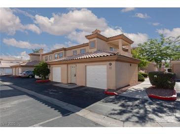 Beautiful townhome featuring a tan stucco exterior, Spanish tile roof, and attached two-car garage at 3608 Pintadas St # 204, Las Vegas, NV 89108