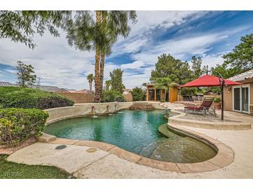 Stunning backyard pool featuring a tropical landscape, custom stone, and a tranquil water feature at 3619 Bixbee Ct, Las Vegas, NV 89129