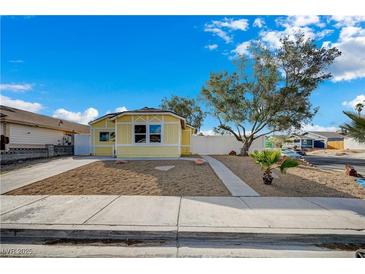 Charming yellow house featuring well-maintained landscaping and a bright blue sky at 4419 Fairmont Cir, Las Vegas, NV 89147