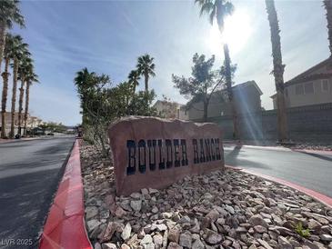 Stone sign for Boulder Ranch neighborhood entrance with palm trees along the road at 6459 Rusticated Stone Ave # 103, Henderson, NV 89011