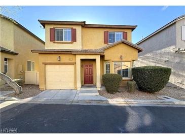 Two-story home featuring an attached garage, well-maintained landscaping, and warm curb appeal at 6777 Wormwood Ln, Las Vegas, NV 89148