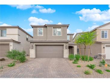 Charming two-story home featuring a brick driveway, neutral color palette and well-manicured landscaping at 7128 Port Stephens St, North Las Vegas, NV 89084