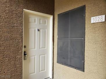Beige front door with six panels, a peephole, and a modern key pad lock; unit number 1028 is visible at 8070 W Russell Rd # 1028, Las Vegas, NV 89113