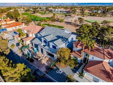 New construction home with a gray roof, stone facade, and a view of the golf course and Las Vegas skyline at 8721 Robinson Ridge Dr, Las Vegas, NV 89117