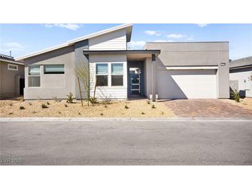 Contemporary home showcasing a modern design, neutral color palette, and a two-car garage, accented by desert landscaping at 9815 Evergreen Pine St, Las Vegas, NV 89166
