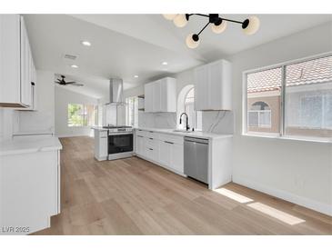 Bright kitchen with white cabinets, stainless steel appliances, and quartz countertops at 1705 Imperial Cup Dr, Las Vegas, NV 89117