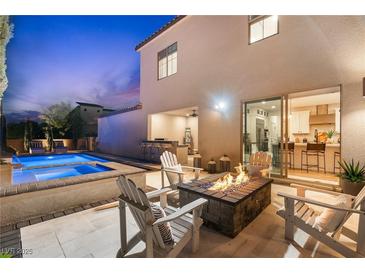 Inviting backyard with a pool, spa, built-in grill, and cozy fire pit area for relaxing evenings at 2710 Marchetti Pl, Henderson, NV 89044
