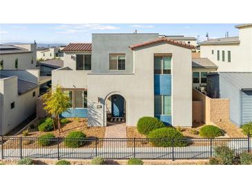 Charming two-story home with desert landscaping, black metal fence, and colorful blue accents at 2710 Marchetti Pl, Henderson, NV 89044