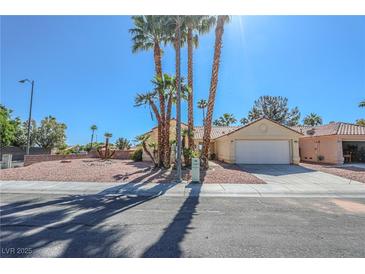 Charming single-story home features a two-car garage, desert landscaping, and swaying palm trees at 4416 Inez Dr, Las Vegas, NV 89130