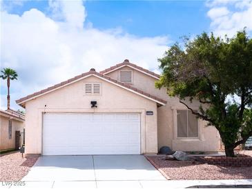 Charming single-story home featuring a two-car garage and desert landscaping under a sunny sky at 5541 Alvarez St, North Las Vegas, NV 89031
