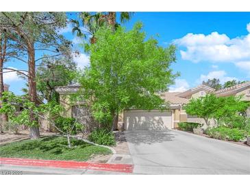 Charming single-story home featuring a neutral color palette, mature trees, and a two-car garage at 6631 Creeping Thyme St, Las Vegas, NV 89148