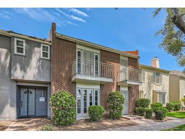 Brick townhome exterior features symmetrical balconies and landscaped front yard, on a bright day at 1034 Tam O Shanter, Las Vegas, NV 89109
