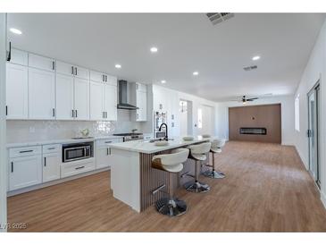 Beautiful kitchen features white cabinets, marble countertops, and a modern island with seating at 1136 Casady Hollow Ave, Henderson, NV 89012