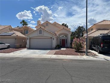 Charming single-story home with a red door, two-car garage, and landscaped front yard at 1249 Lucia Dr, Las Vegas, NV 89128
