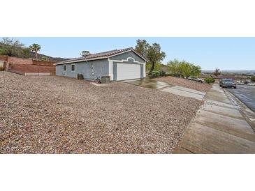 Home exterior featuring a two-car garage, concrete driveway, and low-maintenance rock landscaping at 127 Mauve St, Henderson, NV 89012