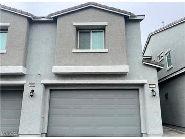 Two-story townhome featuring a gray exterior and a two-car garage at 2585 Amazing Meadows Ave # 1007, North Las Vegas, NV 89031