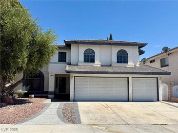 Inviting two-story home featuring a spacious three-car garage and a well-maintained front yard with mature landscaping at 2808 Deep Water Cir, Las Vegas, NV 89117