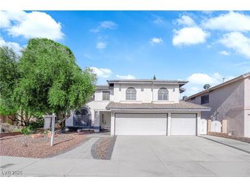 Charming two-story home with a three-car garage, arched windows, and a well-manicured front yard at 2808 Deep Water Cir, Las Vegas, NV 89117