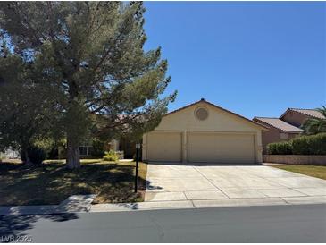 Charming single-story home featuring a two-car garage and well-manicured front yard under a clear blue sky at 5121 Burr Oak Dr, Las Vegas, NV 89130