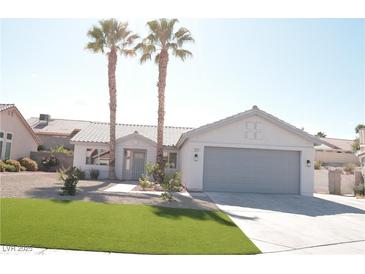 Inviting single-story home featuring desert landscaping, palm trees, and a two-car garage at 7413 Red Eagle St, Las Vegas, NV 89131