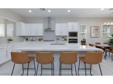 Bright kitchen with white cabinets, quartz countertops, stainless steel appliances, and seating at the large island at 10251 Tiger Milkweed St, Las Vegas, NV 89141