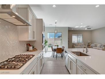 Bright, open kitchen features modern appliances, white cabinets, and a view into the dining and living areas at 10251 Tiger Milkweed St, Las Vegas, NV 89141