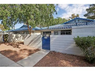 Charming single-story home with blue tile roof, gated courtyard, and mature trees in a well-maintained community at 2128 Petersham Ct # C, Las Vegas, NV 89108
