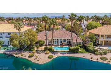 A beautiful backyard featuring a private pool with lush landscaping and waterfront views at 2209 Glenbrook Way, Las Vegas, NV 89117