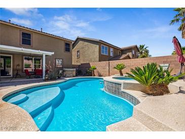 Inviting backyard pool and spa with lush landscaping and covered patio area, perfect for outdoor entertaining at 248 Hyssop Ct, Henderson, NV 89015