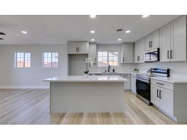Modern kitchen features sleek gray cabinets, stainless steel appliances, and quartz countertops with an island at 4360 El Tovar Rd, Las Vegas, NV 89115