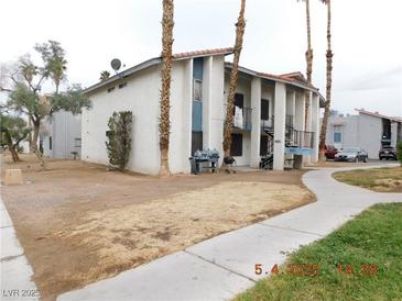 Two-story apartment complex featuring stucco facade, supported columns, and desert landscaping in an arid climate at 4663 Sand Creek Ave, Las Vegas, NV 89103